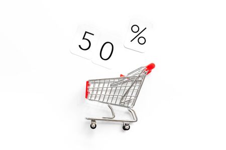 50% off discount sale concept with shopping trolley cart on whiteの写真素材
