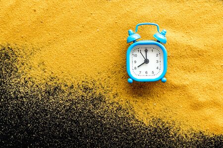 Waste of time concept. Clock on sand on blackの写真素材