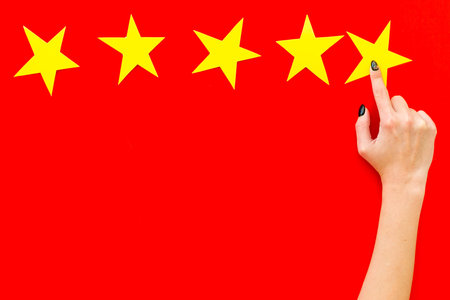 Positive feedback, good service concept. Hand touch the best star on red background top-down copy...