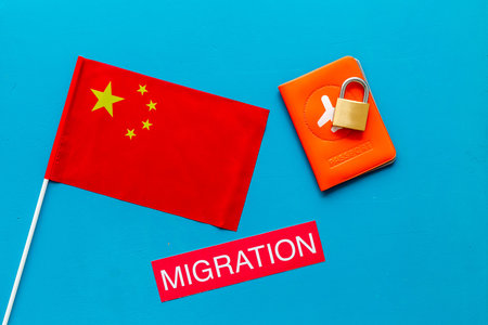 Migration to China concept. Chinese flag near passport and lock on blue background top-downの写真素材