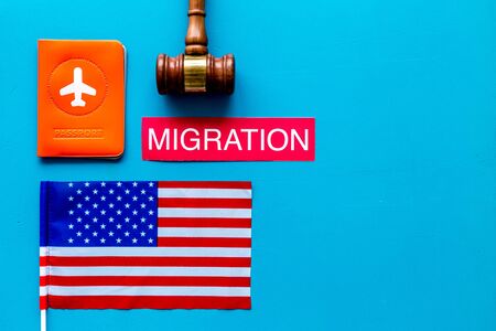 Migration to USA concept. American flag near passport and judge hammer on blue background top-down copy spaceの写真素材