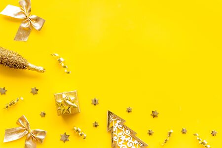 New Year symbols - tree, champagne, decorations - on yellow background top-down frame.の写真素材