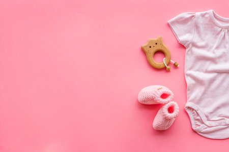 Baby background - pink color. Clothes, booties and accessories for newborn girl on pink table...
