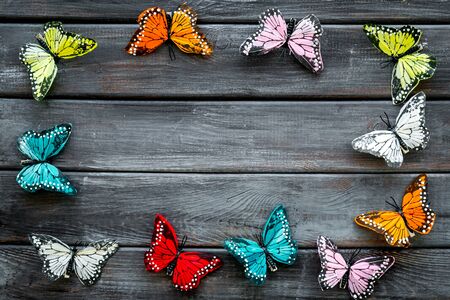 Multicolored tropical butterflies on dark wooden background top-down frame copy spaceの写真素材