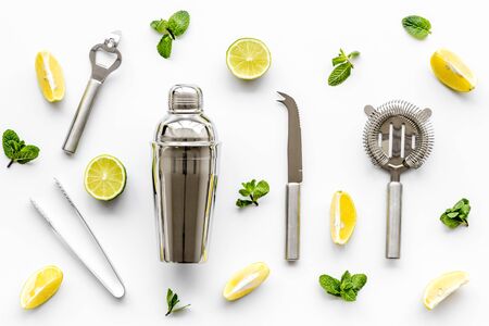 Bartender work desk with equipment and cocktail ingredietns Shaker, lime, ice on white background top-down patternの写真素材