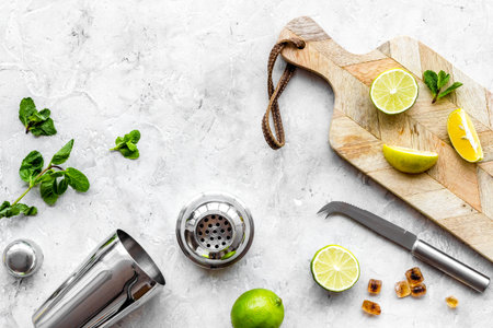 Bar background. Tools and ingredients for making cocktails. Shaker, lime on cutting board on grey background top-down.の写真素材