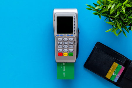 Pay by credit card in shop. Terminal and card on blue background top-down copy space