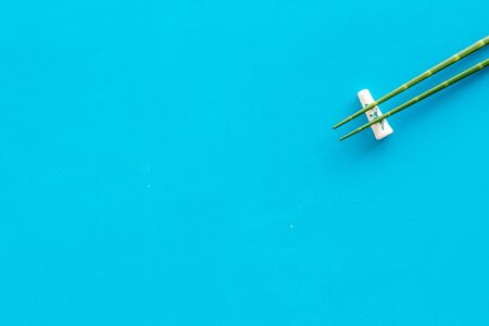 Chopsticks - green wooden utensil for sushi and rolls - on blue background top-down copy spaceの写真素材