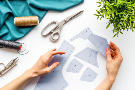 Tailor working. Women hands hold patterns for clothes on white background top-down.の写真素材