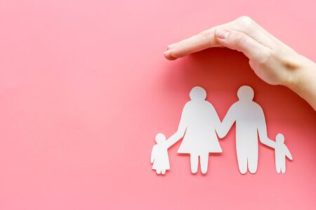 Health insurance concept. Family cutout under palms protect on pink background top-down copy spaceの写真素材
