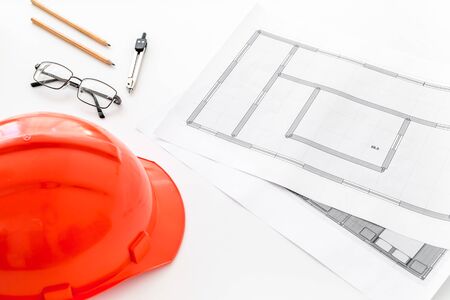 Builder helmet and blueprints on white backgroundの写真素材