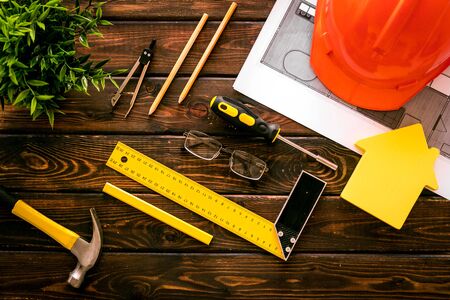 Construction concept. Helmet, instruments on dark wooden background top-downの写真素材