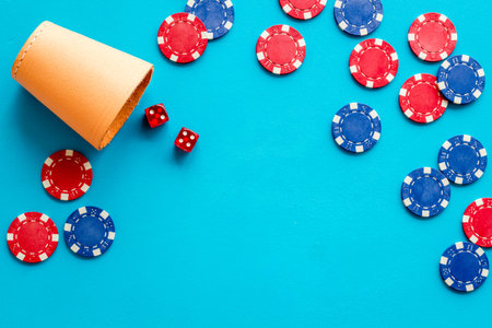 Poker frame. Chips and dices on blue background top-down.