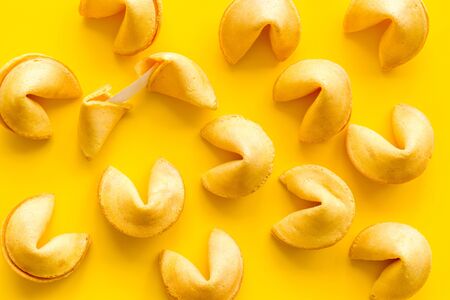 Fortune cookie background on yellow table top-down.の写真素材