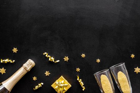 New Year card with champagne glasses - gold color - on black background frame.の写真素材