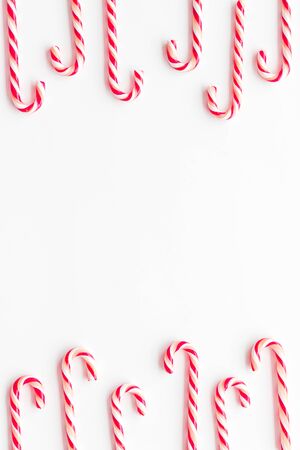 Christmas candies frame - cane with red and white stripes - on white background top-down.の写真素材