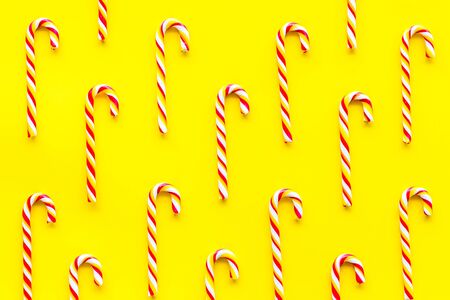Christmas candy cane pattern on yellow background top-downの写真素材