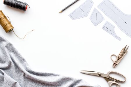 Sewing wokrshop. Textile, pattern, scissors, thread on white background top-down copy spaceの写真素材