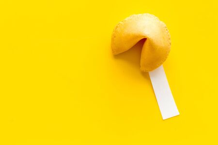 Fortune cookie with prediction inside on yellow background top-down copy spaceの写真素材