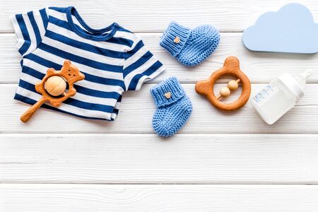Baby background - blue color. Clothes and accessories for newborn boy on white wooden table top-down frame copy spaceの写真素材