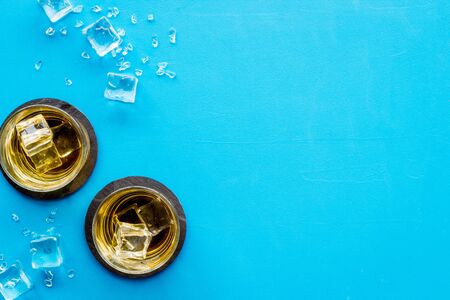 Whiskey near ice cubes on blue background top-down.の写真素材