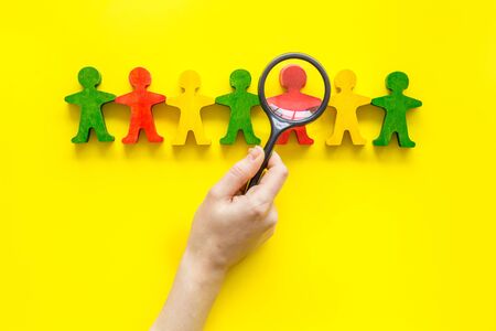 Tolerance concept. Social research. eople cutouts under magnifier on yellow background top-down.の写真素材