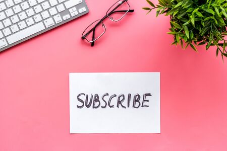 Subscribe. Text on pink office desk top-downの写真素材