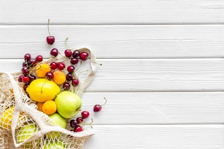Textile eco bag with fruits on white wooden background top-down copy spaceの写真素材