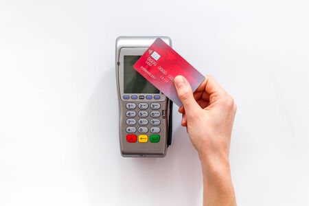 Contactless payment, paypass. Hand hold bank card near terminal on white background top-downの写真素材