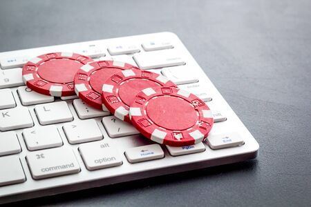 Gambling, online games. Chips near keyboard on lack background.の写真素材