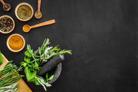 Herbs and spices on black kitchen desk top-down.の写真素材