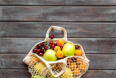 Eco trend. Textile bag for shopping on dark wooden background top-down copy spaceの写真素材