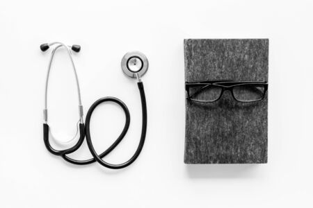 Medical books near stethoscope on white background top-down.の写真素材