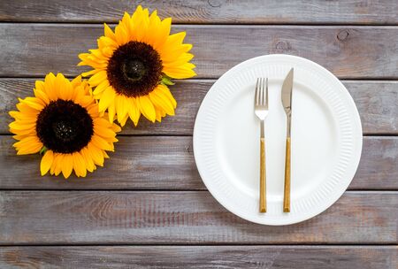Dinning table decorated with sunflower, dark wooden background top-downの写真素材