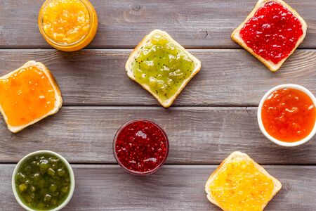 Toast with jam on dark wooden background.
