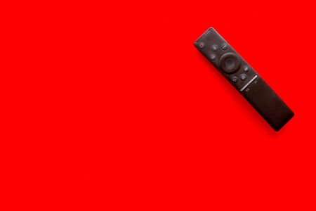 Television air recording concept. TV remote on red background top-down copy spaceの写真素材
