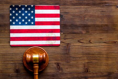 Law and justice in USA concept. Judge gavel near american flag on dark wooden background top-down.の写真素材