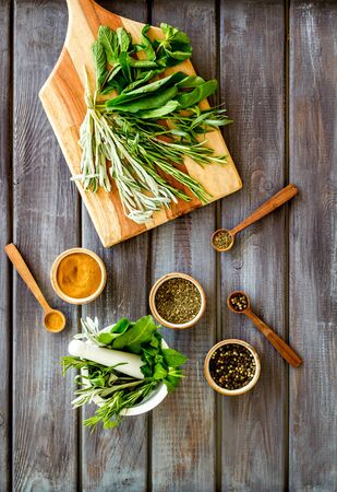 Herbs and spices on dark wooden kitchen desk top-down.の写真素材