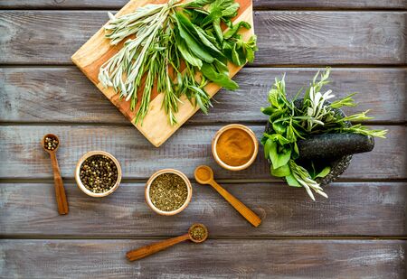 Herbs and spices on dark wooden kitchen desk top-down.の写真素材