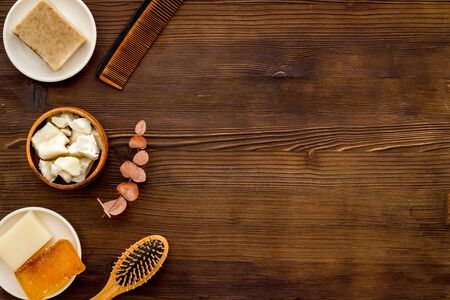 Hair care concept. Coconut oil, brush on dark wooden background top-down frame copy spaceの写真素材