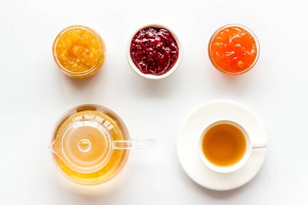 Fruit jam near tea on white kitchen desk.の写真素材