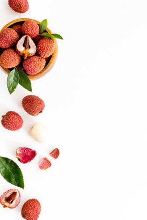 Fresh ripe lychee in bowl on white desk top-down frame copy spaceの写真素材
