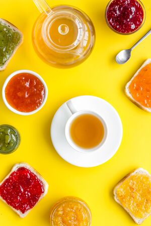 Tea party with jam. Toast, teapot, cup on yellow backgroundの写真素材