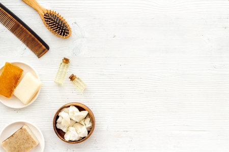 Cosmetics for hair care with argan and jojoba oil on white background top-down frame copy space
