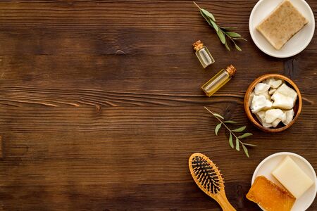 Hair care concept. Coconut oil, brush on dark wooden background top-down frame copy spaceの写真素材