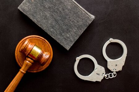 Arrest concept. Handcuffs near judge gavel on black background top-downの写真素材