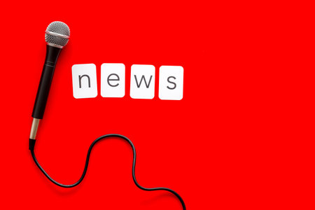 Breaking news concept. Microphone on red background top-down.の写真素材