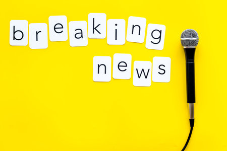 Breaking news concept. Microphone on yellow background top-down.の写真素材