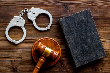 Arrest concept. Handcuffs near judge gavel on dark wooden background top-down.の写真素材