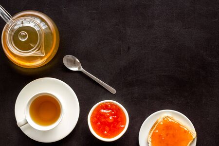Tea party with jam. Toast, teapot, cup on black background frame copy spaceの写真素材